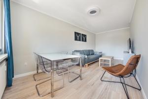 a living room with a table and chairs and a couch at Apartamenty Sun & Snow Kopernika in Ustka
