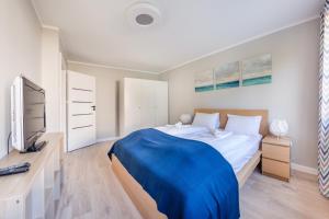 a bedroom with a large bed and a tv at Apartamenty Sun & Snow Kopernika in Ustka