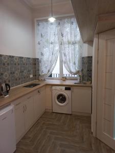 a kitchen with a washing machine and a window at Сьоме Небо in Lviv