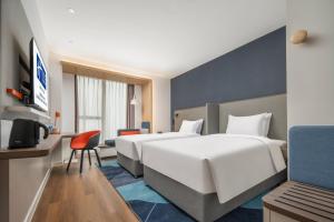 um quarto de hotel com duas camas e uma secretária em Holiday Inn Express Chengdu Tianfu Airport Zone, an IHG Hotel em Jianyang