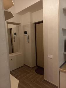 a small bathroom with a door and a mirror at Сьоме Небо in Lviv