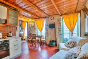 a kitchen and living room with a couch and a table at Apartments In The Heart of Medieval Village - Happy Rentals in Apricale