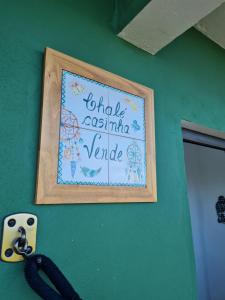 a picture of a sign on a green wall at Village as casinhas in Uruçuca