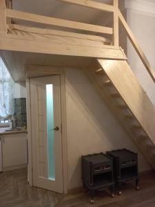 a loft bed with two drawers and a door at Сьоме Небо in Lviv +4 photos