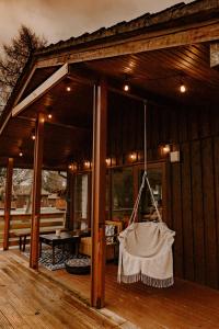 a porch of a wooden house with a swing at Wooden Cosy Retreat Hunters Quay in Dunoon