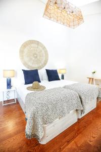 a bedroom with a large white bed with blue pillows at Watermelon Sugar Apartment in Faro