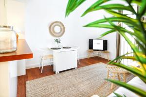 a living room with a desk and a tv at Watermelon Sugar Apartment in Faro