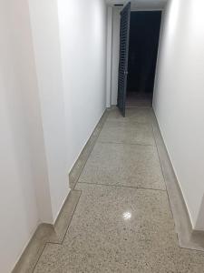 um corredor com uma porta numa parede branca em Apto 101 em Cúcuta