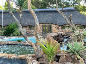 a house with a swimming pool in front of a house at Sambane Game Lodge 