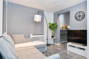 a living room with a couch and a clock on the wall at Impeccable 4-Bed House in Brixton London in London