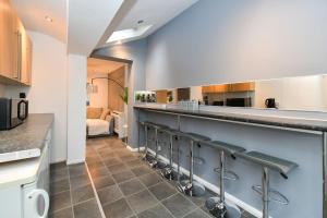 a kitchen with a bar with stools at Impeccable 4-Bed House in Brixton London in London