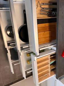 a cupboard with doors open in a kitchen at LUX Business Apartments in Weil am Rhein