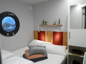 a small room with two beds and a window at Hausboot Fjord Lyra mit Biosauna in Barth in Barth