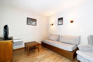 a living room with a couch and a tv at Appartement Résidence Albane Vars in Vars