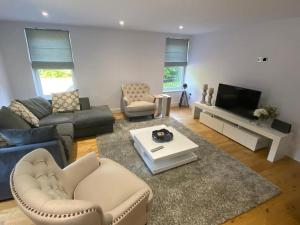 a living room with a couch and a tv at New Ground floor apartment, 4 mins walk to beach in Bournemouth