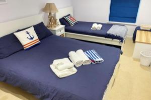a bedroom with two beds with towels on them at New Ground floor apartment, 4 mins walk to beach in Bournemouth