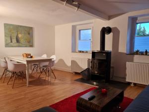 a living room with a table and a stove at Schönste Lage am Rhein, behagliches Haus mit Kamin. in Cologne