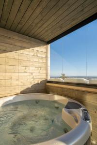 a bath tub in a room with a large window at Ski-Inn Kultakero in Pyhätunturi