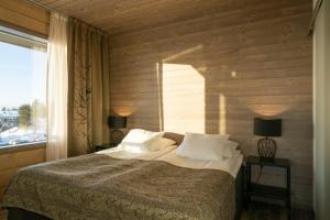 a bedroom with a bed with two lamps and a window at Ski-Inn Kultakero in Pyhätunturi