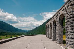 an old stone bridge with mountains in the background at Hotel Hvala Superior - Topli Val in Kobarid