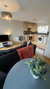 uma sala de estar com um sofá e uma mesa com um vaso em At home in the city serviced apartments Newport em Newport