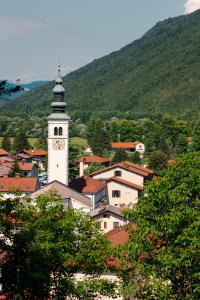 a clock tower on top of a town with a mountain at Hotel Hvala Superior - Topli Val in Kobarid