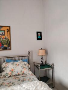 um quarto com uma cama e uma mesa com um candeeiro em BRUSSELS HOMESTAY BALIGE em Balige