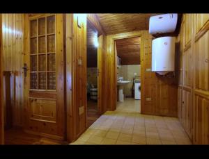 Łazienka z drewnianymi ścianami, toaletą i umywalką w obiekcie CASA MENFREY w mieście Verrayes