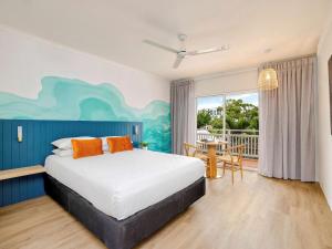 a bedroom with a bed and a table and a dining room at Mercure Cairns in Cairns