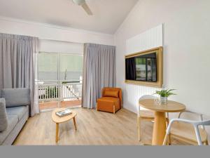 a living room with a couch and a table at Mercure Cairns in Cairns