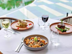 a table with a bowl of food and glasses of wine at Mercure Cairns in Cairns