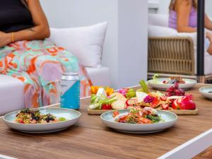 a wooden table with plates of food on it at Mercure Cairns in Cairns