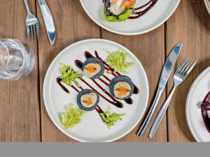 two plates of food with eggs and broccoli on a table at Mercure Cairns in Cairns