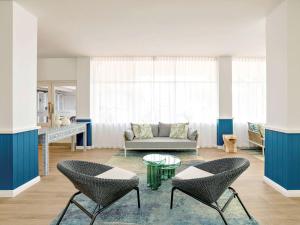 a living room with a couch and chairs and a table at Mercure Cairns in Cairns