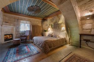 a bedroom with a bed and a fireplace at Anatolian Houses Cave Hotel & SPA in Goreme