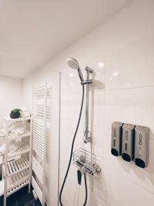 um chuveiro numa casa de banho com uma parede branca em Beatrix Home Vienna Luxury Stay em Viena