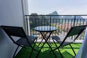 two chairs and a table on a balcony with a view at Ipoh Tambun Lost World Sunway Onsen Suites Aria 2R2B 8 paxs in Tambun