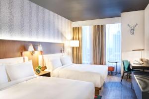 a hotel room with two beds and a piano at Hyatt Centric Downtown Denver in Denver