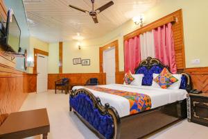 a bedroom with a bed and a television in it at Royal Green Buds - Near Chamunda Devi Temple in Pathyar