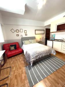 um quarto com uma cama e um sofá vermelho em Apartament in Principe Real em Lisboa