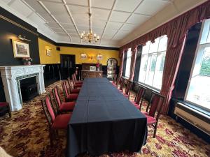 a conference room with a long table and chairs at The Grange Hotel in Bury Saint Edmunds