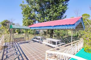 a pavilion with picnic tables and benches in a park at Royal Green Buds in Pathyar
