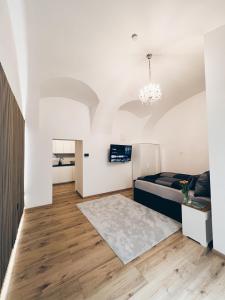 1 dormitorio con paredes blancas, 1 cama y suelo de madera en Beatrix Home Vienna Luxury Stay, en Viena