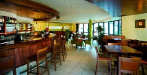 un ristorante con bar e tavoli e sedie in legno di Hotel Millanderhof a Bressanone
