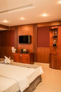 een slaapkamer met een bed en een flatscreen-tv bij Lien Do Star Hotel in Bao Loc