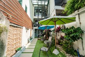 a patio with a table and an umbrella and chairs at Luxury Industrial Flat in the Heart of Chiang Mai in Chiang Mai