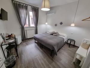 a bedroom with a bed and a table and a window at Residenza Tarzanà in Palermo
