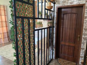 uma porta de madeira com um portão ao lado de um quarto em Alnoor Mirbat em Salalah