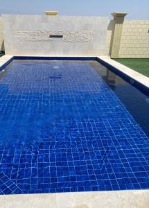 a swimming pool with blue tiles on top of it at Alnoor Mirbat in Salalah