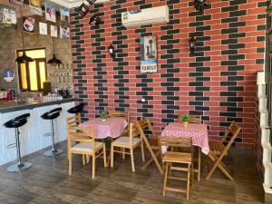 restauracja ze stołami i krzesłami oraz ceglaną ścianą w obiekcie Alnoor Mirbat w mieście Salala